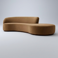 Canapé asymétrique moderne sans accoudoirs, au design raffiné et décontracté, avec une silhouette généreusement rembourrée et une base en bois brun, idéal pour appartement et école