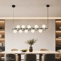 Luminaire suspendu linéaire élégant en forme de nuages, avec sphères en verre chromé blanc et métal noir, pour cuisine moderne ou îlot de cuisine.
