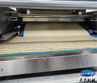 Machine à laminage continu de pâte avec système d'arrosage pour la production de biscuits soda et de biscuits en forme de panda