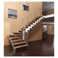Escalier de luxe avec structure en acier inoxydable poli, marches en pierre naturelle, garde-corps en verre trempé