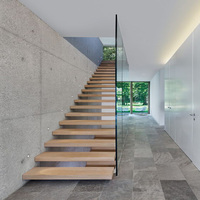 Escalier mural flottant sur mesure avec marches en bois visuelles pour villa de luxe à plan ouvert