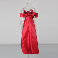 Gaun pesta wanita tanpa tali, model high-low dengan ruffle, warna merah merah tua, asimetris, dengan detail cascading di sisi, mini di bagian depan, dan ekor panjang.