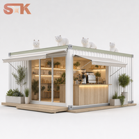 Kiosque à café blanc sur le thème des animaux avec sculpture de chat, motif de patte sur le toit et façade vitrée