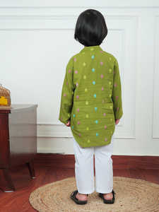 Niño pequeño con kurta verde estampada y pijama blanco, sonriendo y riendo mientras se encuentra en el interior de una casa con un atuendo tradicional. - Product Image 2