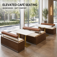 Banc de café avec coussin crème et traversin marron, table en marbre avec piédestal doré, chaises et tables pour restaurant ou café