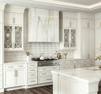 Armoire de cuisine sur mesure de luxe blanche à panneaux surélevés avec porte en verre décorative, quincaillerie dorée, grand îlot de cuisine pour la rénovation de la maison