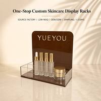 Expositor de acrílico marrón personalizado, plegable y portátil para productos de cuidado de la piel, bandeja de mostrador con respaldo redondeado para botellas de suero y spray.