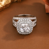 Bague de fiançailles de luxe pour femme en laiton plaqué platine, sertie de zircon taille coussin, double halo et triple rangée de pavé de zircon cubique, vente en gros