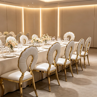 Chaise de salle à manger de luxe en acier inoxydable doré avec pieds courbes, dossier ajouré festonné et revêtement blanc, idéale pour mariages et banquets