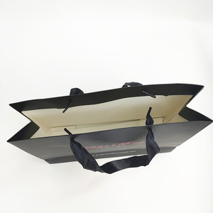 Bolsa de regalo de papel negro de lujo al por mayor, bolsa de papel con asas de satén y logotipo de marca impreso personalizado para empaque de tiendas de moda - Product Image 2