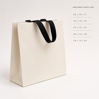 Sacs shopping personnalisés en papier kraft blanc avec poignée en ruban noir, soufflets latéraux et fond plat – Sacs promotionnels style Instagram pour la vente au détail