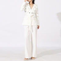 Ensemble deux pièces automne 2026 pour femme : haut à col en V et manches longues avec appliques et poches, et pantalon taille haute