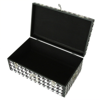 Malle de rangement moderne recouverte de tissu noir et blanc avec passepoil en cuir et accessoires à serrure argentée