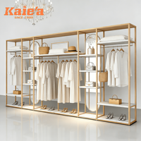 Étagère de présentation de vêtements en métal doré sur mesure pour magasin de vêtements féminins