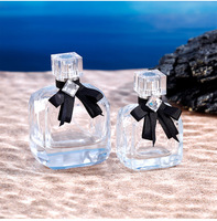 Vente en gros de flacons carrés en verre transparent de 50 ml avec finition mate, nœud noir, couvercle en acrylique anti-fuite, pompe pulvérisatrice pour parfum