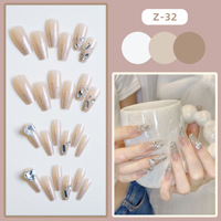 Faux ongles à presser rose nude forme cercueil avec pointes françaises à paillettes argentées et accents de cristaux pour soirées romantiques