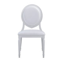 Chaises de restaurant empilables blanches Louis avec coussins crème pour la restauration, les banquets ou les mariages, idéales pour les parcs