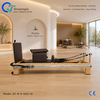 Reformer de Pilates pleine longueur en bois de chêne brun foncé avec barre de repose-pieds spécialisée pour les salles de sport commerciales et les salles d'entraînement en groupe