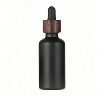 Ensemble d'emballages en verre noir mat avec bouchon en bois foncé, compte-gouttes pour sérum, vaporisateur pour tonique et pot pour crème visage