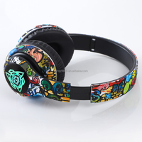 Casque sans fil nouvellement lancé pour enfants Casque en métal à faible retard Conception de graffiti populaire pour l'utilisation du téléphone portable de voyage sportif