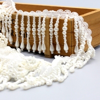 Robe de mariée élégante et professionnelle avec des franges de perles et des chaînes de perles
