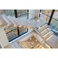 Escalier intérieur en bois avec garde-corps en verre et main courante latérale