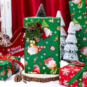 Papel de regalo navideño de doble cara con diseño de Papá Noel, gnomos y copos de nieve en rojo y verde, estilo cuadro sobre papel calcomanado. - Product Image 1