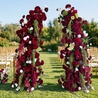 Composition florale en soie rouge bordeaux personnalisée, arche florale incurvée irrégulière avec des lianes vertes suspendues pour toile de fond de mariage d'automne