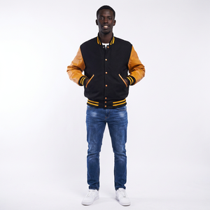 Blouson universitaire noir avec manches jaune beige, bordure côtelée, corps en laine, boutons-pression, col montant, logo frontal, style bomber universitaire personnalisé - Product Image 1