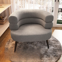 Chaise longue en laine d'agneau à dossier incurvé, structure en bois massif, toucher doux et moelleux, texture texturée, silhouette arrondie, luxe contemporain