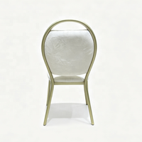 Chaise d'événement empilable en métal doré avec poignée intégrée dans le dossier et coussin blanc pour hôtels et salles de banquet