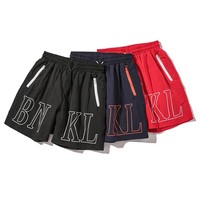 Shorts de sport décontractés en nylon extensible écologique avec logo personnalisé pour hommes, parfaits pour la gym, la plage et les activités sportives.