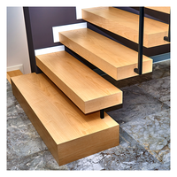 Escalier flottant cantilever avec supports muraux simples, marches en chêne blanc, main courante en métal noir, escalier au design moderne