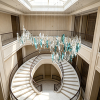 Lustre en verre à feuilles dentelées uniques, style art contemporain, avec pendentifs en cristal cyan et transparent, idéal pour l'éclairage des halls d'hôtel et des escaliers