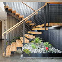Escalier intérieur moderne à monopoutre avec garde-corps en câble et marches en bois massif
