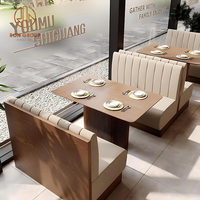 Ensemble de meubles de restaurant moderne Table de café ronde en bois brun avec chaises en cuir beige et cabine de canapé incurvée pour café