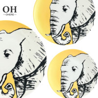 Service de table en porcelaine fine série animale, décor jaune mat, comprenant tasses et soucoupes, assiette de présentation en céramique motif éléphant