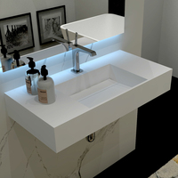 Évier artistique moderne à surface solide avec robinet monotrou pour lavabo intégré dans la salle de bain de l'hôtel