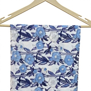 Beaux tissus ornés de motifs floraux bleus avec des fleurs et des feuilles sur un fond blanc créant un style traditionnel élégant. - Product Image 1