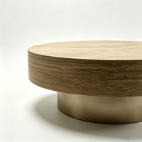 Table basse moderne en bois avec piétement doré champagne, plateau texturé aspect pierre, table centrale circulaire pour salon
