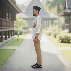 Kurta SIPO Malaisie <span class=keywords><strong>blanc</strong></span> avec des grilles fines sombres, haut de fête à col rond pour hommes, <span class=keywords><strong>pantalon</strong></span> kaki apparié casquette traditionnelle sur chemin en bois - Product Image 1