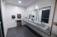 Unité de toilettes portable moderne, durable, écologique et personnalisable avec station de lavage des mains en panneaux sandwich pour événements publics extérieurs
