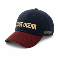 Casquette en velours côtelé bicolore avec logo personnalisé et lettrage en relief, bleu marine et bordeaux, pour la cabane de pêche Waterfront Creek Basin, avec logo métallique marron