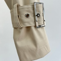Trench-coat beige sur mesure à revers, coupe courte, avec taille cintrée