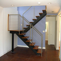 Balustrade contemporaine en fil d'acier inoxydable avec poteaux ronds pour escalier intérieur et zone d'accueil d'appartement