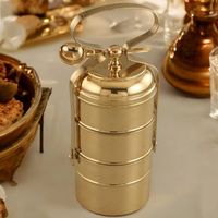 Boîte à lunch robuste en laiton avec système de fermeture étanche assurant que les repas restent chauds, frais et séparés lorsqu'on les transporte au bureau.