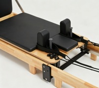Reformer de Pilates pliable haut de gamme, cadre en bois massif à articulations, avec charnières pliantes robustes apparentes, portable