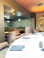 Projet de rénovation de restaurant haut de gamme : table ronde en marbre demi-cercle, mobilier de restaurant, ensemble de canapés et banquette.
