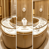 Solution de mobilier sur mesure pour bijouterie : Vitrine îlot incurvée, présentoir mural, finition or champagne, éclairage LED