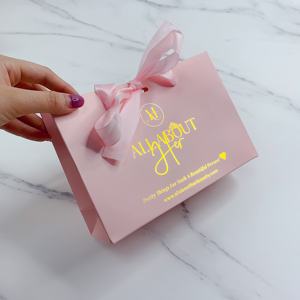 Sac en papier rose de luxe avec logo personnalisé en feuille d'or pour l'emballage de bijoux, de cosmétiques et de lunettes, avec poignée en ruban - Product Image 1